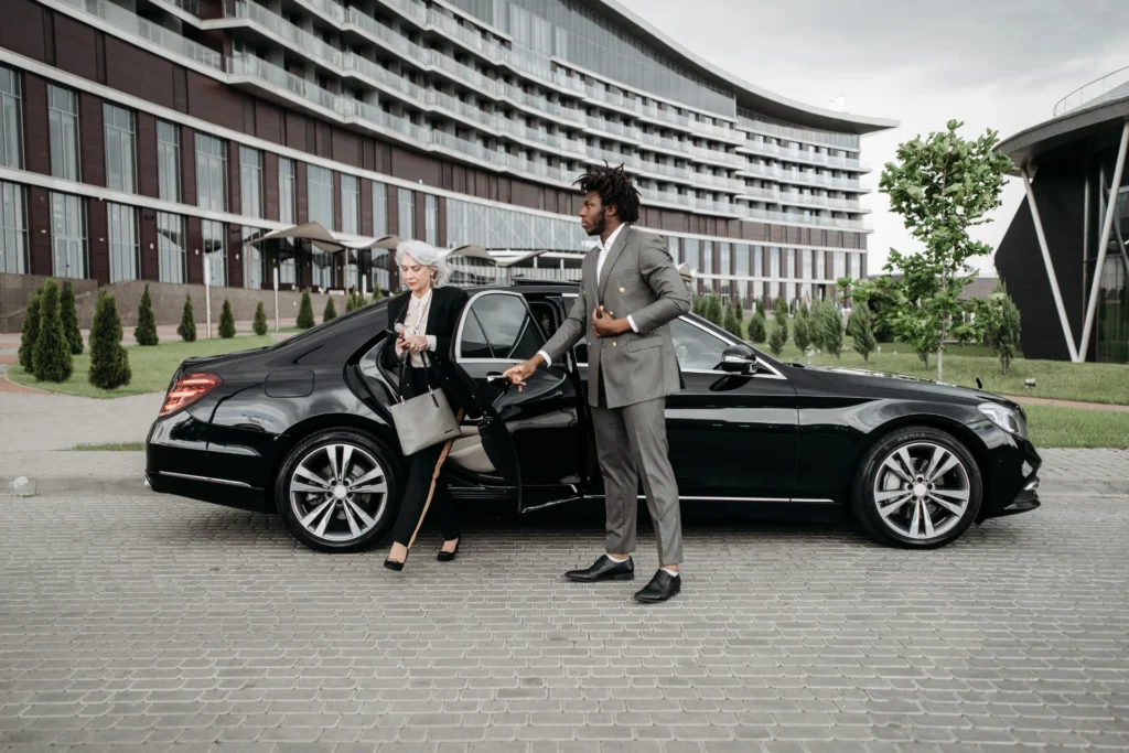Chauffeur öffnet Tür einer schwarzen Mercedes Limousine – Flughafentransfer Frankfurt