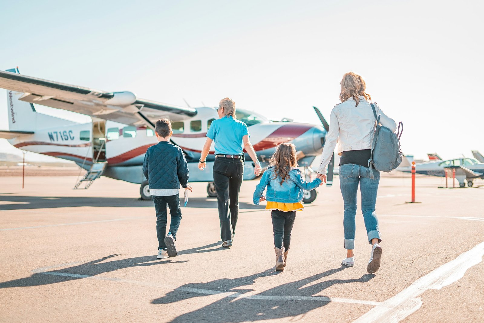Mutter und Tochter mit Gepäck auf dem Weg zum Flugzeug – Flughafentransfer Frankfurt mit Kindern